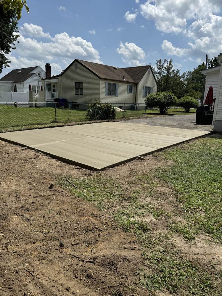 Large concrete slab pad freshly poured in a residential backyard by South Jersey Construction Enterprise